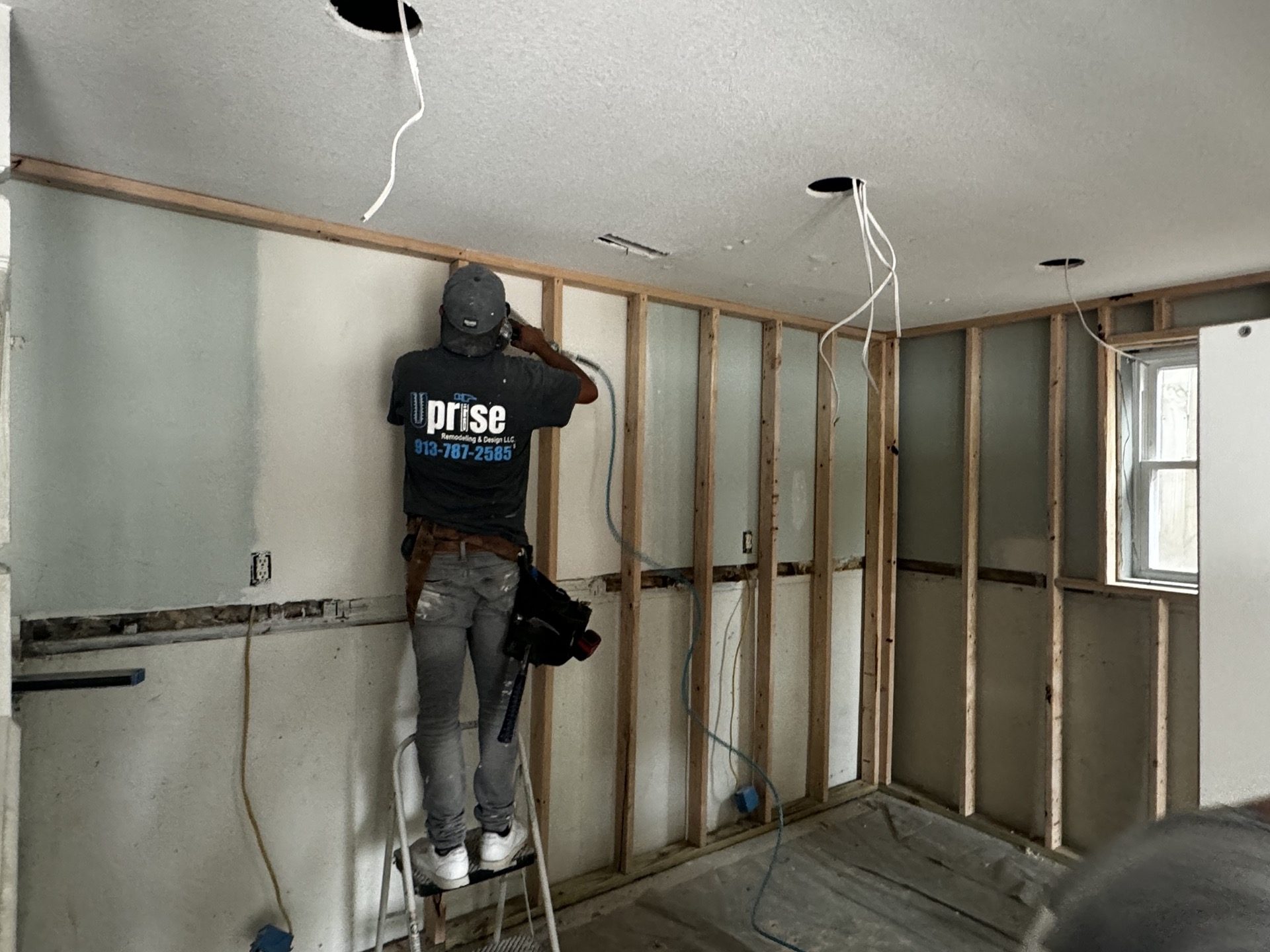 Uprise team member doing framing and electrical work